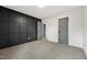 Bedroom with a dark accent wall, neutral carpet, and a gray door at 109 Mohawk Dr, Louisburg, NC 27549