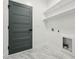 Clean laundry room featuring a gray door, marble floors, and white shelving above the machines at 109 Mohawk Dr, Louisburg, NC 27549