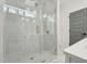 A modern glass shower featuring white marble tile and gold hardware fixtures at 109 Mohawk Dr, Louisburg, NC 27549