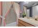 Bathroom featuring a shower-tub combo with pink-trimmed curtain and neutral vanity at 1101 Esher Ct, Raleigh, NC 27609