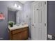 Bathroom showcasing a vanity with sink and wallpaper design, plus a white door at 1101 Esher Ct, Raleigh, NC 27609