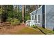 Exterior view of a blue house with white trim and a small porch surrounded by greenery at 1101 Esher Ct, Raleigh, NC 27609