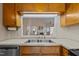 Kitchen sink area showcases stainless steel appliances, wood cabinets, and a pass-through window at 1101 Esher Ct, Raleigh, NC 27609