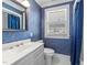 Bathroom with patterned wallpaper, white vanity, large mirror, and window at 1106 Aycock Ave, Burlington, NC 27215