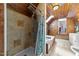 Rustic bathroom with knotty pine walls, tiled shower, soaking tub, and skylight at 1106 Aycock Ave, Burlington, NC 27215