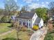 A lovely white home showcasing a covered porch, mature trees, and a manicured lawn at 1106 Aycock Ave, Burlington, NC 27215