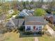Aerial of bright home featuring white exterior, covered porch, and manicured lawn with mature trees at 1106 Aycock Ave, Burlington, NC 27215