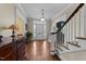 Inviting foyer with hardwood floors, white trim, staircase, and coat storage at 1106 Aycock Ave, Burlington, NC 27215
