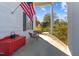 Inviting front porch featuring a bright red storage bench and an American flag, adding a touch of patriotism at 1106 Aycock Ave, Burlington, NC 27215