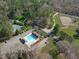 Aerial view showcasing community pool, tennis courts and riding stables surrounded by lush trees at 11808 Black Horse Run, Raleigh, NC 27613
