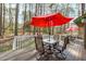 Back deck features metal patio furniture and a red umbrella at 11808 Black Horse Run, Raleigh, NC 27613
