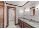 Bathroom featuring a double granite vanity, hardwood trim and view into adjacent bath area at 11808 Black Horse Run, Raleigh, NC 27613
