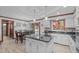 Bright kitchen with granite countertops, white cabinets, wood floors, an island, and view to dining room at 11808 Black Horse Run, Raleigh, NC 27613