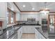 Modern kitchen with granite counters, stainless steel appliances, wood floor, and mosaic tile backsplash at 11808 Black Horse Run, Raleigh, NC 27613