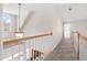 Upstairs hallway featuring a chandelier and staircase at 1217 Wedgeland Dr, Raleigh, NC 27615