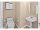 Cozy powder room with pedestal sink, toilet, and framed artwork, offering simple elegance at 1217 Wedgeland Dr, Raleigh, NC 27615