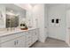 Modern bathroom featuring a double vanity, large mirror, and a glass-enclosed shower with tiled walls at 1222 Coach Station Alley # 101, Raleigh, NC 27601