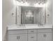 Bright bathroom featuring double sinks, vanity, and large mirror at 1226 Coach Station Alley # 101, Raleigh, NC 27601