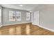 Spacious bedroom with large windows, light walls, and beautiful hardwood flooring at 1226 Coach Station Alley # 101, Raleigh, NC 27601