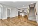 Open-concept living area with hardwood floors, a staircase, and a view into the kitchen at 1226 Coach Station Alley # 101, Raleigh, NC 27601