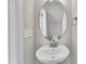 A clean, well-lit powder room with an oval mirror and modern sink fixture at 1226 Coach Station Alley # 101, Raleigh, NC 27601