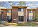 Back exterior view of a two-story brick townhome, with a patio area and grill overlooking the backyard at 1245 Schaub Dr, Raleigh, NC 27606