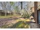 Large grassy backyard with mature trees, a privacy fence, and the exterior wall of the home at 1245 Schaub Dr, Raleigh, NC 27606