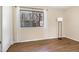 Cozy bedroom featuring hardwood floors and a large window offering a view of a landscaped backyard at 1245 Schaub Dr, Raleigh, NC 27606