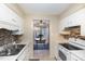 Functional kitchen with white cabinets, tile backsplash, and appliances next to the light-filled dining area at 1245 Schaub Dr, Raleigh, NC 27606