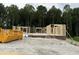 New home construction with wooden frame and brick foundation set against a backdrop of lush trees at 129 Tigris Ct, Zebulon, NC 27597