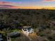 An aerial view of a home surrounded by lush trees, with a beautiful sunset in the distance at 1318 Ivy Ln, Raleigh, NC 27609