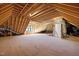 Unfinished attic space with exposed wood framing, and natural light from window at 1318 Ivy Ln, Raleigh, NC 27609
