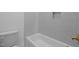 Clean, white bathroom with a soaking tub and a tiled wall niche at 1318 Ivy Ln, Raleigh, NC 27609
