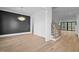 Open concept dining room showcases hardwood floors, decorative black wall paneling, and modern stairway at 1318 Ivy Ln, Raleigh, NC 27609