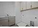 Laundry room featuring overhead cabinets, a sink, and utility connections at 1318 Ivy Ln, Raleigh, NC 27609