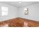 Large bedroom with refinished hardwood floors, two windows and fresh paint at 1409 Ida St, Durham, NC 27705