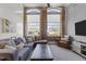 Comfortable living room with exposed brick, large windows, and a plush sectional couch at 1535 Caraleigh Mills Ct # 105, Raleigh, NC 27603