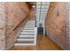Unique staircase with exposed brick walls and hardwood flooring creates a historic aesthetic at 1535 Caraleigh Mills Ct # 105, Raleigh, NC 27603