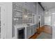 Stylish bar area with a sink, beverage fridge, open shelving, and unique backsplash at 1535 Caraleigh Mills Ct # 105, Raleigh, NC 27603