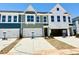 View of townhomes with varied exteriors and attached garages and driveways on a sunny day at 158 Nimble Way # 226, Clayton, NC 27520