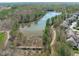 An aerial view of a picturesque lake surrounded by lush greenery and walking paths in a residential area at 162 Arabella Ct, Cary, NC 27518