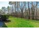Well-maintained backyard with lush green grass, a metal fence, and mature trees at 162 Arabella Ct, Cary, NC 27518