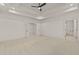 Large bedroom with crown moulding, neutral carpet, and white paint with multiple doors at 162 Arabella Ct, Cary, NC 27518