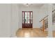 Bright foyer featuring hardwood floors, a staircase, and a glass-paneled front door providing natural light at 162 Arabella Ct, Cary, NC 27518