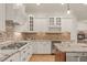 Gourmet kitchen featuring white cabinets, granite countertops, and high-end appliances at 162 Arabella Ct, Cary, NC 27518