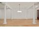 Expansive living area featuring hardwood floors, decorative pillars, and a modern chandelier at 162 Arabella Ct, Cary, NC 27518