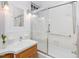 Bright bathroom featuring a shower-tub combo with glass doors and classic white tile at 1628 Park Dr, Raleigh, NC 27605