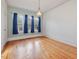 Sunlit bedroom with hardwood floors, three windows with curtains, and light blue walls at 1628 Park Dr, Raleigh, NC 27605