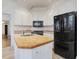 Kitchen showcasing white cabinets, black appliances and butcher block countertop at 1628 Park Dr, Raleigh, NC 27605