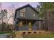 Modern two-story home featuring a metal roof, expansive windows, and inviting front porch at 168 Daphine Dr, Hillsborough, NC 27278